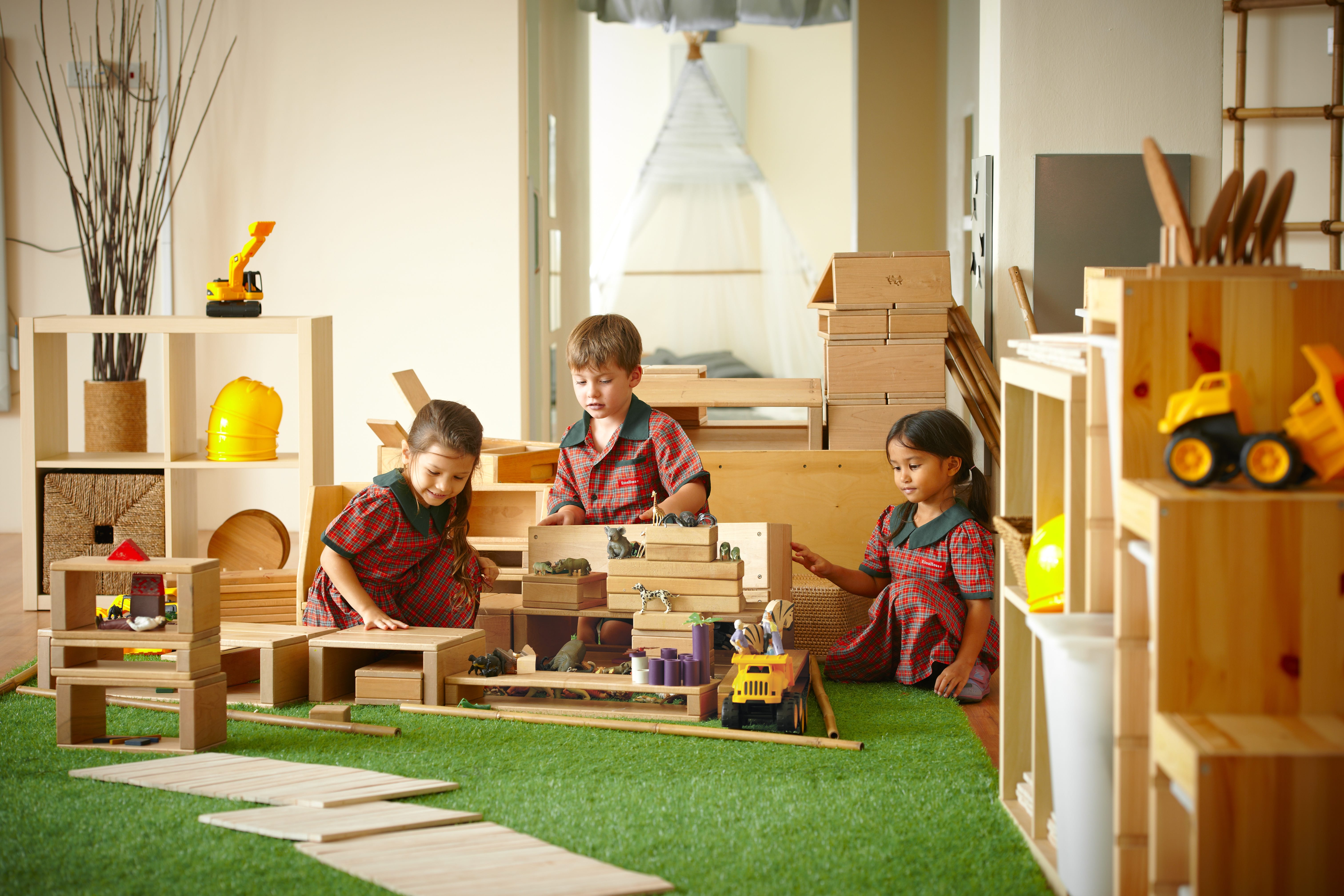 Three students at EtonHouse International School playing with blocks