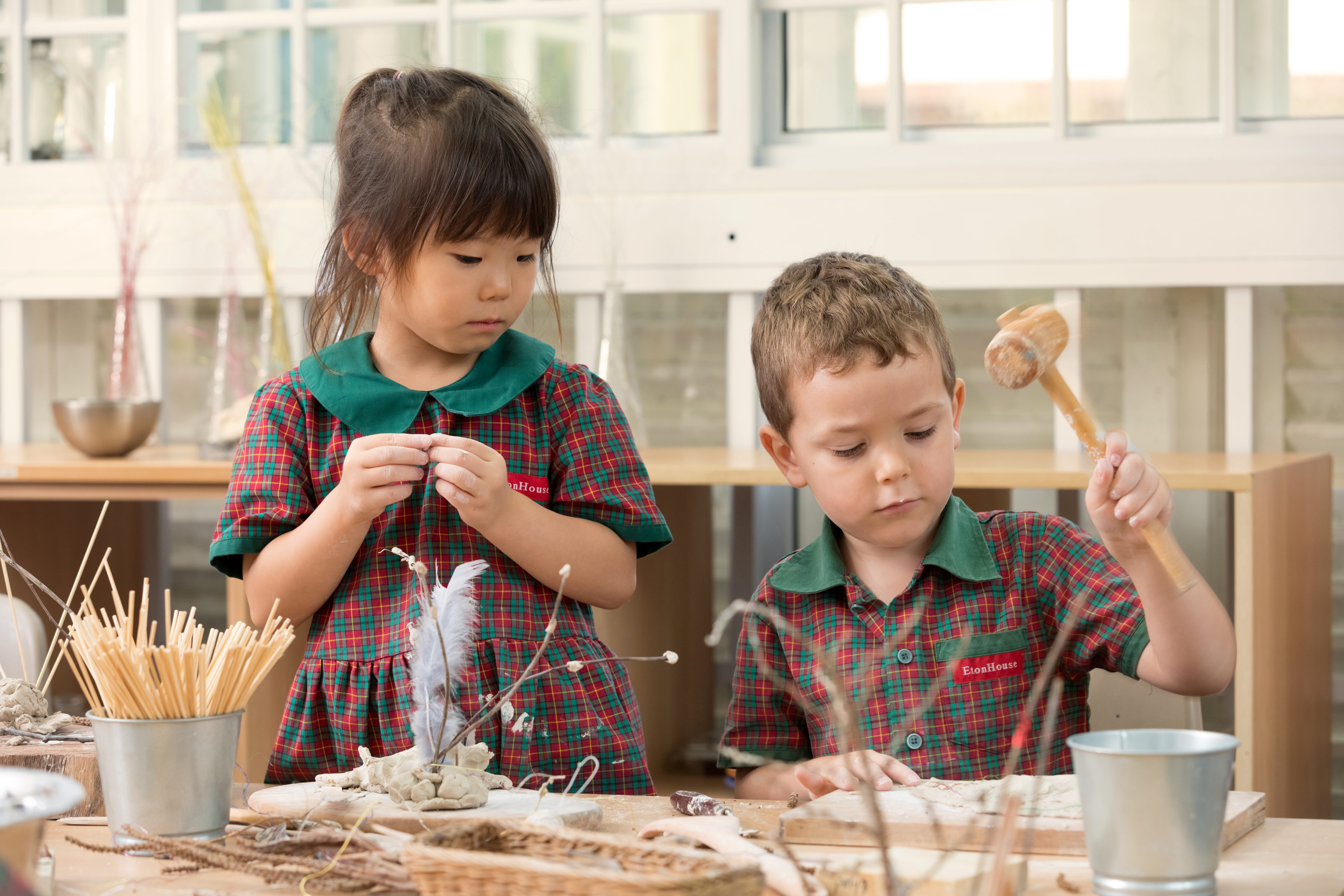 Two students of EtonHouse Nature Pre-school working on clay modeling