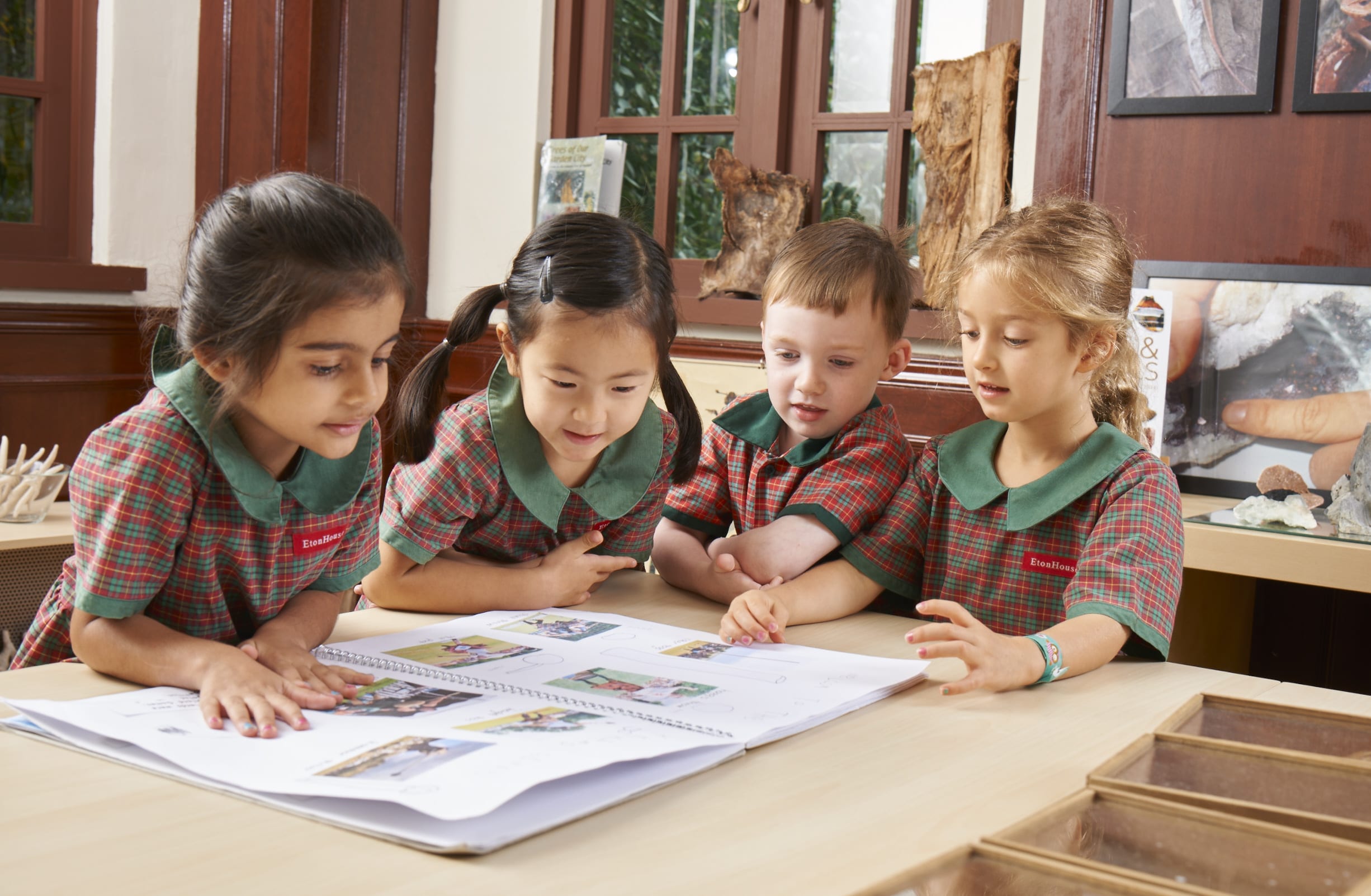 Four EtonHouse students engaged with their activity book.