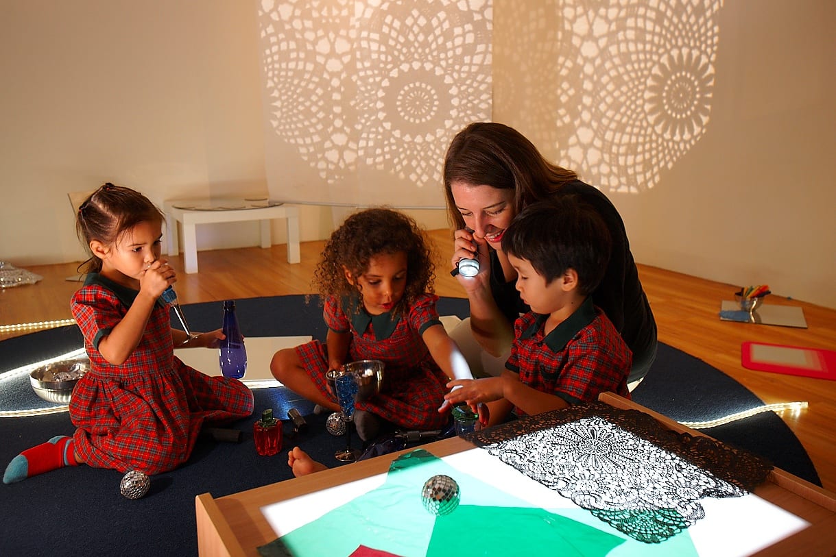 Teacher demonstrating to students how to create shadow patterns using their hands