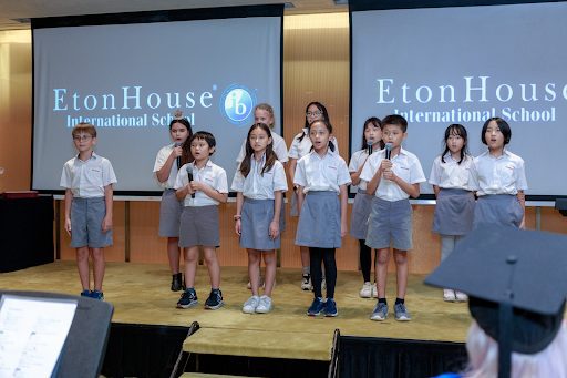 Students singing on stage during an Etonhouse event