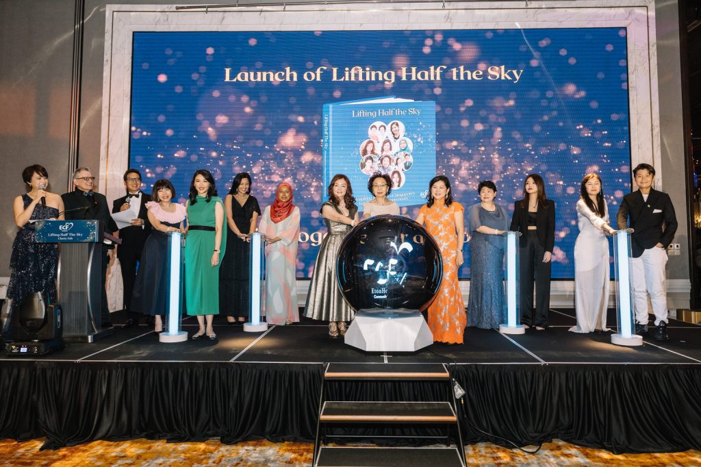 Attendees at a event posing with a giant globe