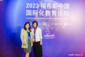 Forbes China Award attendees posing in front of a billboard