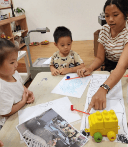 Teacher guiding students for their art project