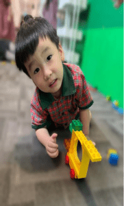 Little boy playing with legos on the floor