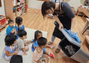 Teacher showing students the contents of a bin