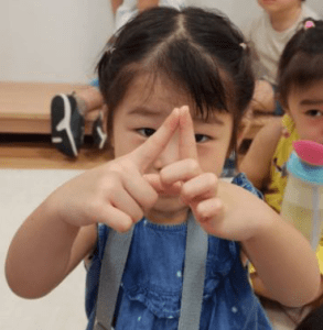 Little girl making a triangle shape with her fingers