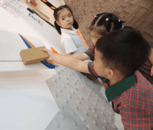 Students examining a model planes wing