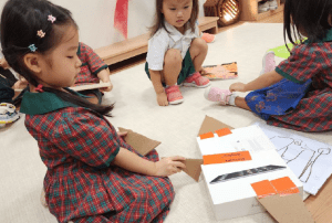 Student attaching cardboard parts to her plane