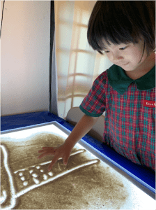 Little girl using a large etch a sketch
