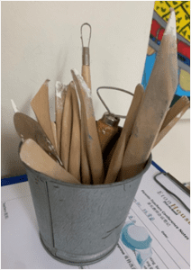 Bucket full of diferent art related tools