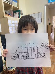 Student showing off their drawing of Singapore