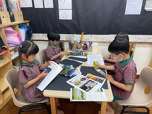 Preschool students using magazine clippings for their art project