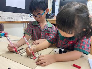 Students colouring using red markers