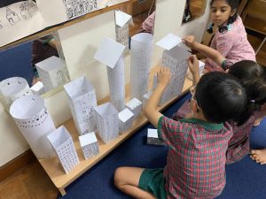 Students creating buidings and skyscrapers using paper