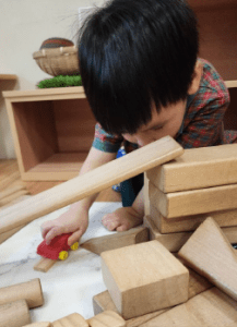 Little boy using wooden blocks during playtime
