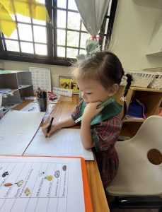 Little girl noting down what she knows about food