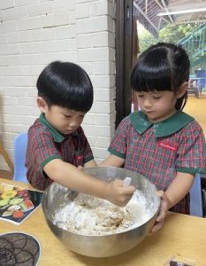 Students mixing dough in a bowl using a spoon