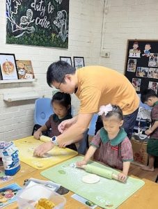 Teacher instructing students on how to use a rolling pin