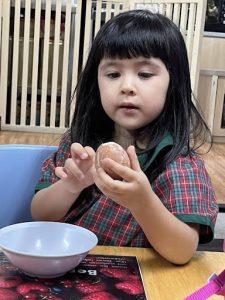 Young girl peeling a hard boiled egg
