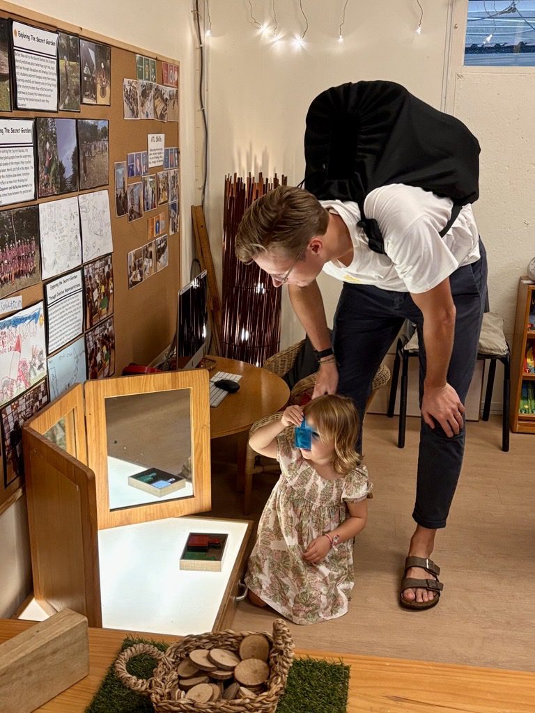 An EtonHouse Broadrick educator exploring a light-table activity with a young child